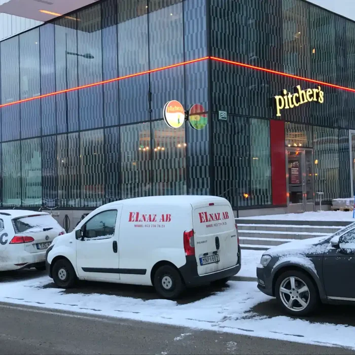 Framåtbelysta bokstäver för Pitcher's på Hornsbergsstrand hängades på glasfasaden med en neonramp i rött runt hela byggnaden.