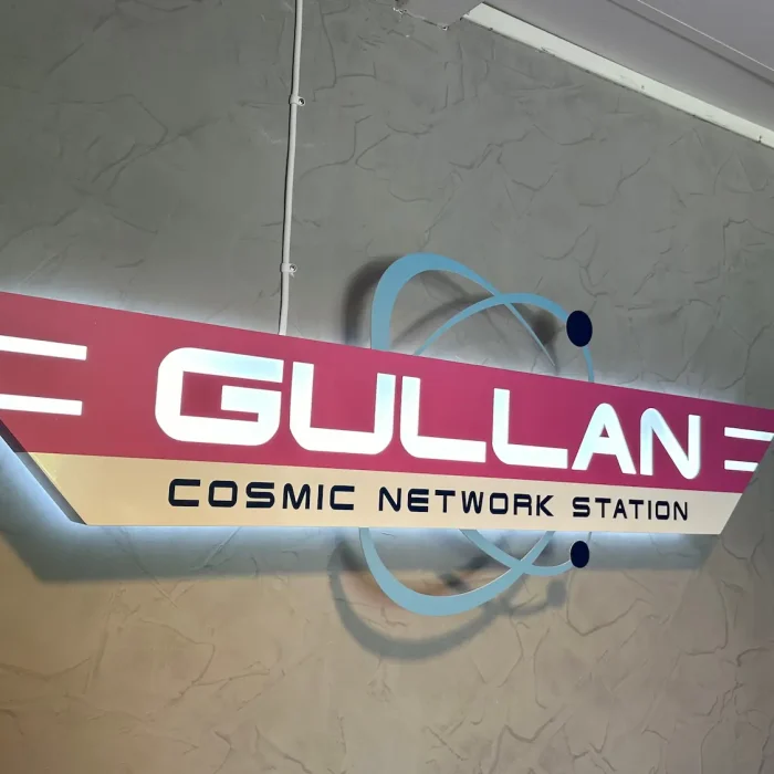 Retro-futuristisk inomhus reklamskylt för Gullan Cosmic Network Station i Stockholm, med unik design och belysning.