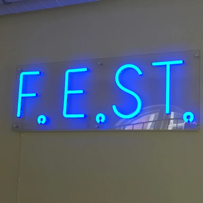 Neonskylt Stockholm – Blå LED-neonskylt med texten F.E.S.T monterad på vägg.