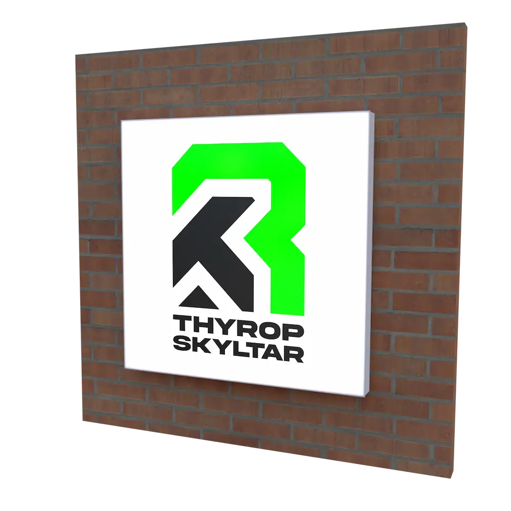 Kvadratisk ljuslåda med färgstark logotyp för företaget Thyrop Skyltar, monterad på tegelvägg – en tydlig och modern fasadskylt för företag.