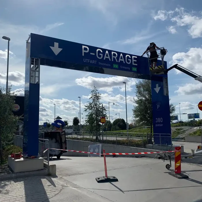 Montering av stor företagsskylt utomhus vid Barkarby Gate – tydlig skylt för parkeringsutfart.