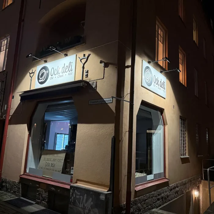 Delikatessbutik i Nynäshamn med dubbla belysta plåtskyltar – ett snyggt exempel på plåtskyltar i Stockholmsområdet.