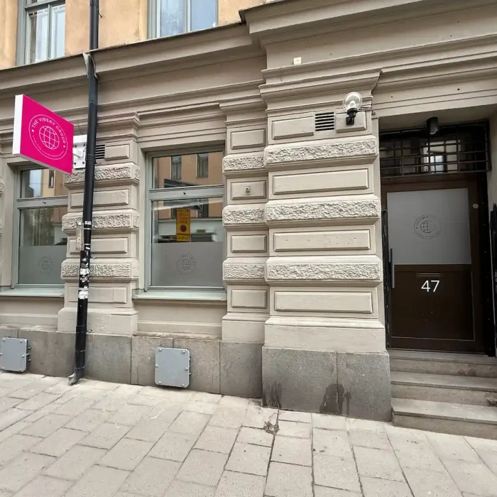 Företagsskylt på fasad för The Vibery Group – elegant skyltlösning i stadsmiljö med fönsterdekor.